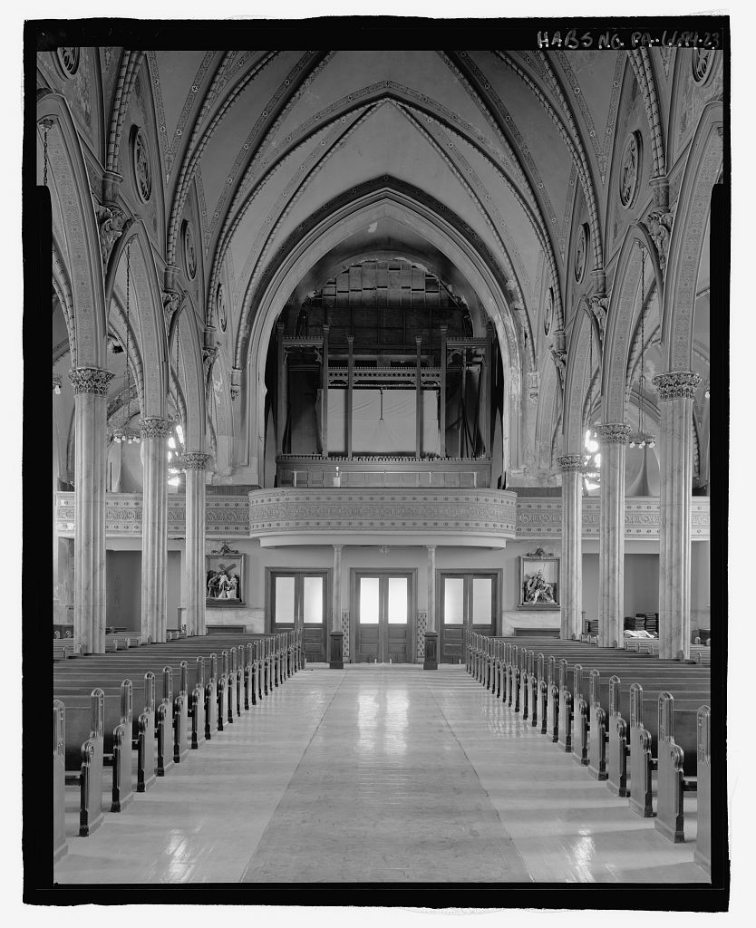 View of high gothic revival vaults and carved wood organ case inside a historic Philadelphia church.